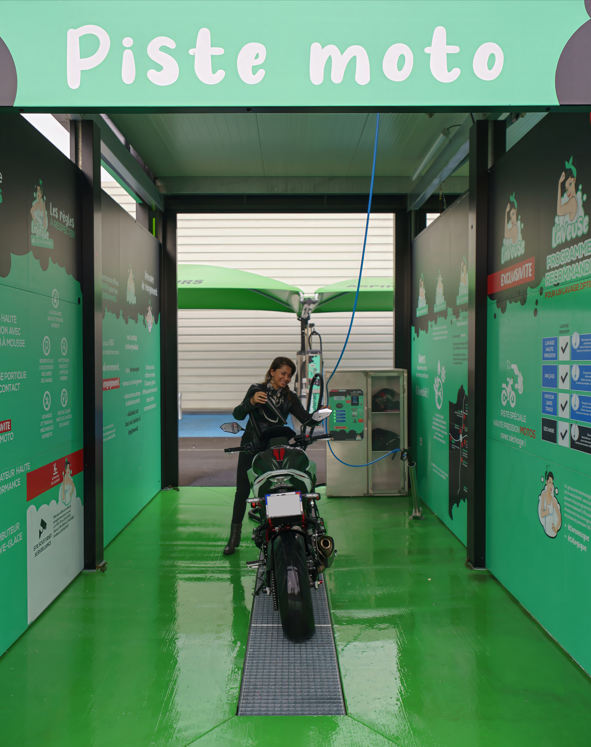 Cliente sur la piste moto du centre de lavage Pollestres, utilisant le souffleur et le casier étanche, lavage haute pression écoresponsable.