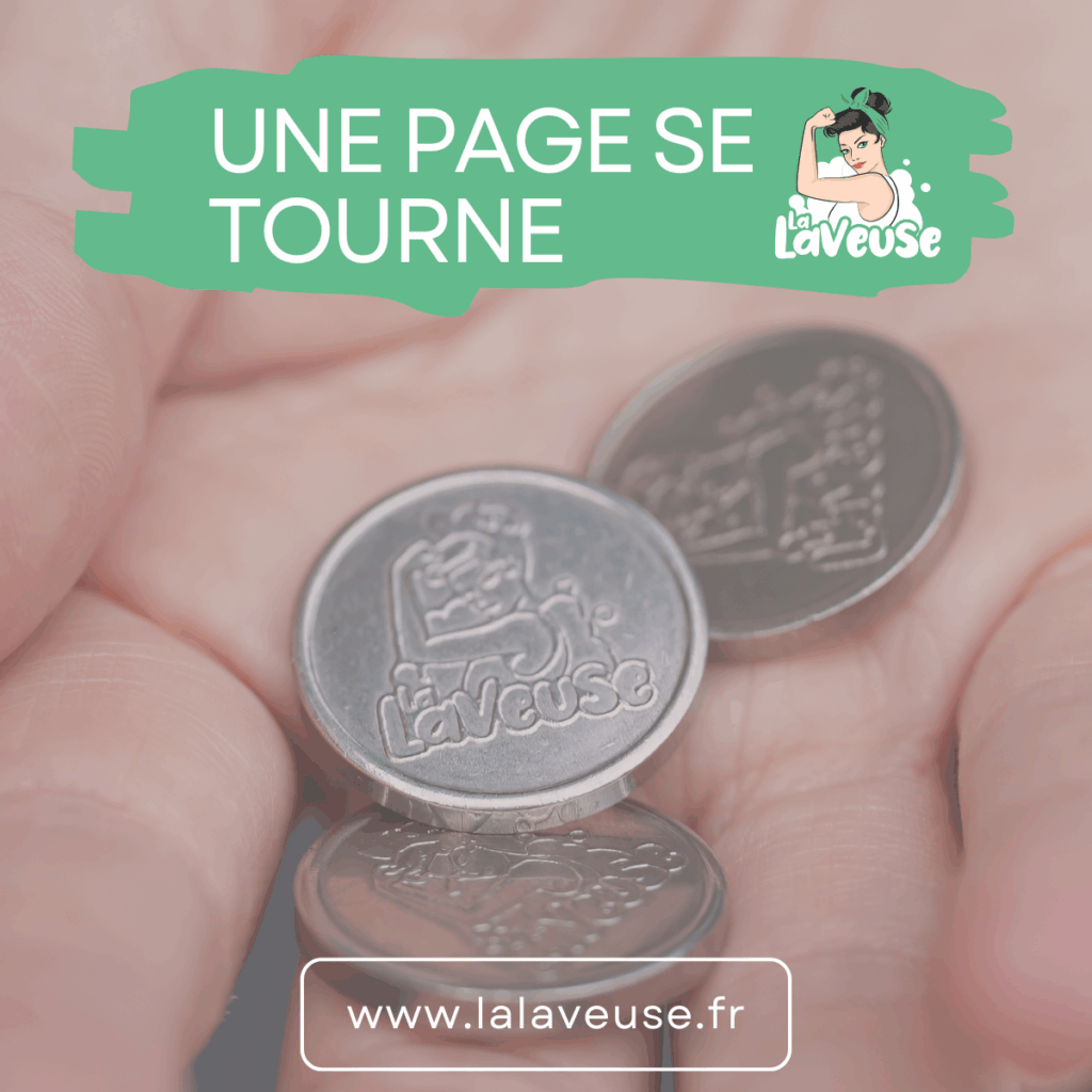 Main tenant plusieurs jetons métalliques avec le texte “Une page se tourne”, symbolisant la fin du système de jetons dans tous les centres La Laveuse.